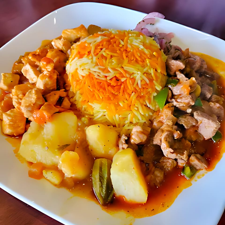 Middle-Eastern dish with orange and white rice, chicken, beef, potatoes, and okra in a rich sauce.