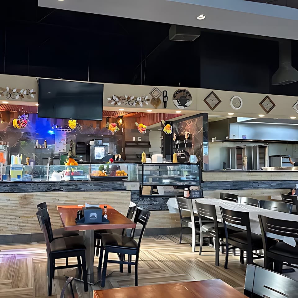 Interior of Queen of Sheba Imperial Restaurant with dining tables, chairs, and a food service counter.
