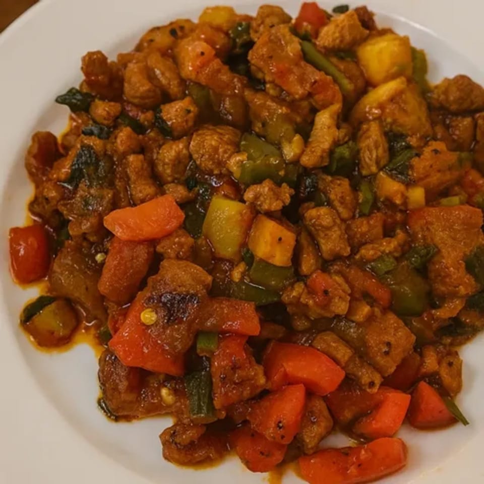 A close-up of a vibrant Middle Eastern dish with meat, red and green peppers, and other vegetables.